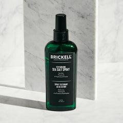 Brickell spray en mano durante la aplicación para crear volumen natural
