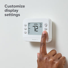 Honeywell Home X2P comparación de tamaño junto a una mano para escala
