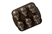 Nordic Ware caja delantera del molde Haunted Skull mostrando diseño bronce y ventaja estética