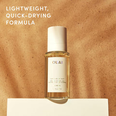 OUAI bottle on palm-lined beach towel conveying island scent escape benefit