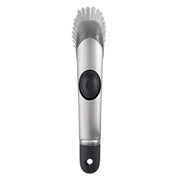OXO cepillo frontal con mango mostrando diseño ergonómico y dosificación de jabón