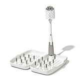OXO Tot front view of compact travel drying rack showing organized bottles and pegs