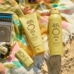 Niño usando Sun Bum stick facial en playa mostrando protección activa