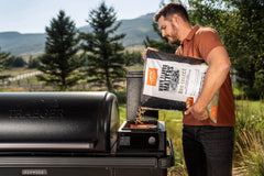 saco Traeger 30 lb comparado con manos para mostrar escala y conveniencia