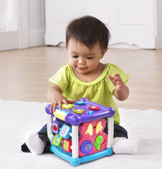 VTech cubo en uso con bebé jugando, promoviendo motricidad fina y curiosidad
