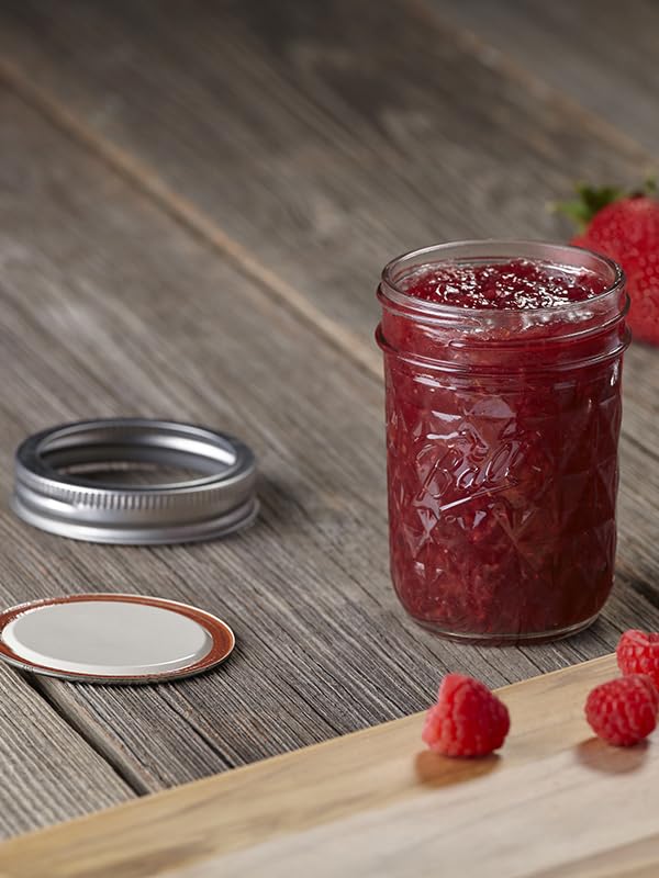 Ball lids on jars inside a water bath canner illustrating safe processing