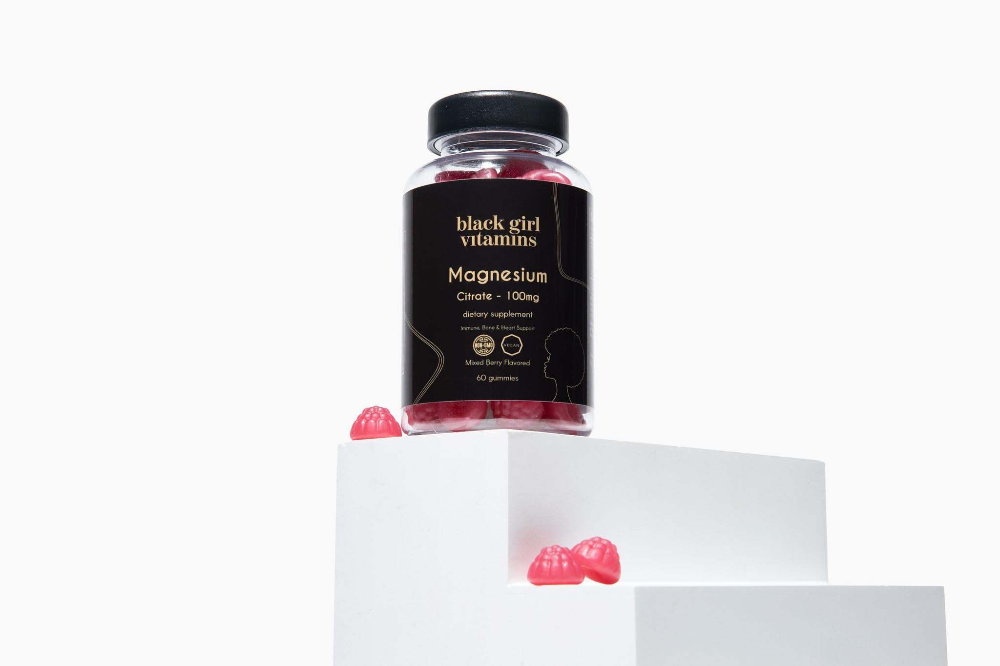 Black Girl Vitamins gomita junto a moneda para comparar tamaño