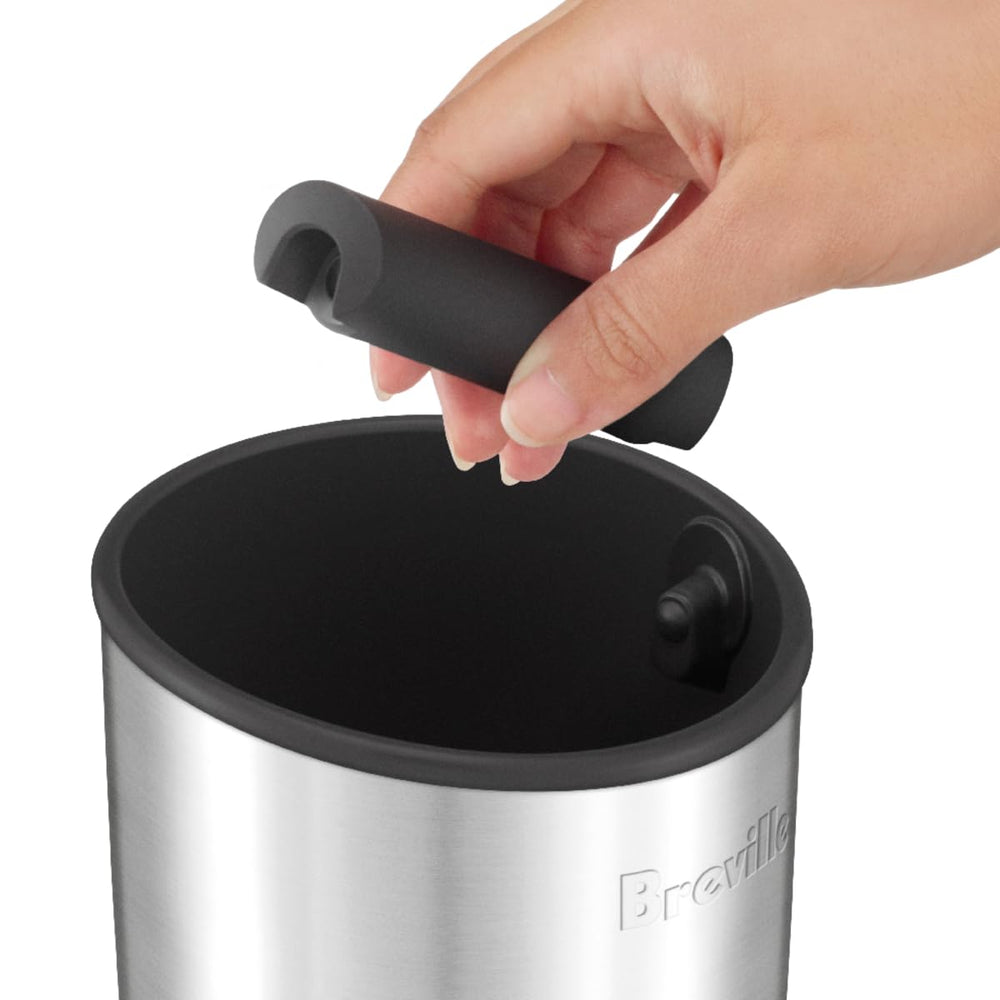 Breville knock box 10 en uso golpeando portafiltro, acelera limpieza entre cafés