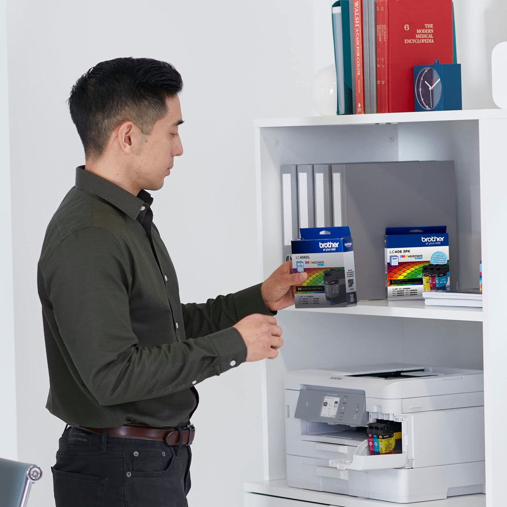 Brother LC406 beside smartphone for size comparison and compact storage benefit
