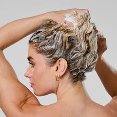 Bumble and bumble aplicación en cabello mojado demostrando limpieza suave y anti-frizz
