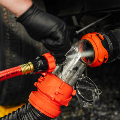 Camco Rhino Blaster next to sewer hose illustrating compact size and portability