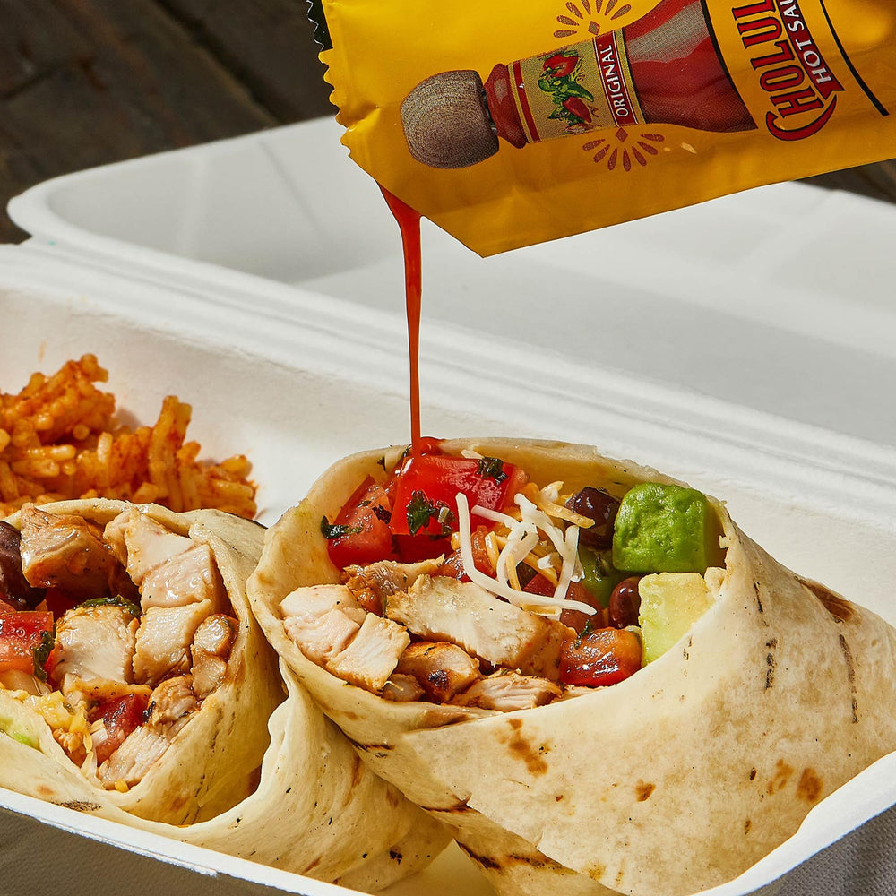 Cholula sobre al lado de papas que realza snacks y platos informales