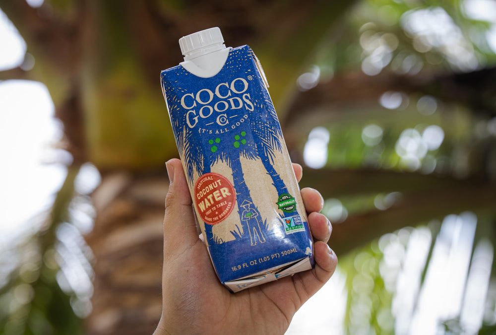 CocoGoodsCo botella junto a un coco partido, evidencia fuente natural del producto