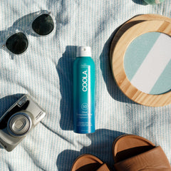 COOLA mist texture in air showing clear finish and quick absorption benefit