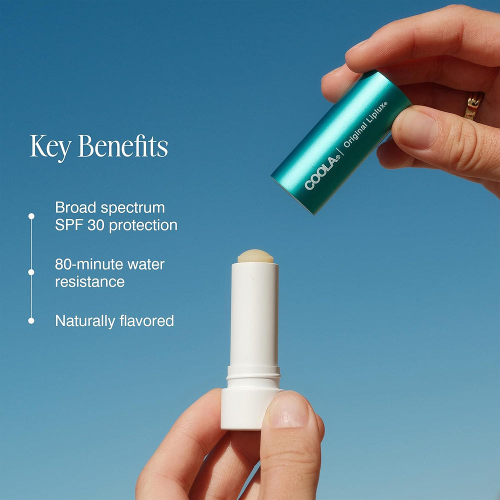 COOLA Liplux envase 0.15 oz junto a monedas para comparar tamaño