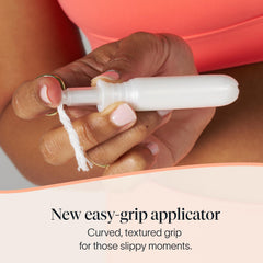 Cora tampon and applicator next to coin indicating compact portable size