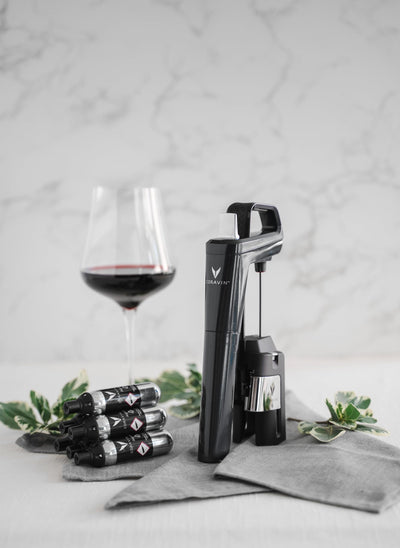 Coravin in-use pouring wine with capsule connected for preserved glasses