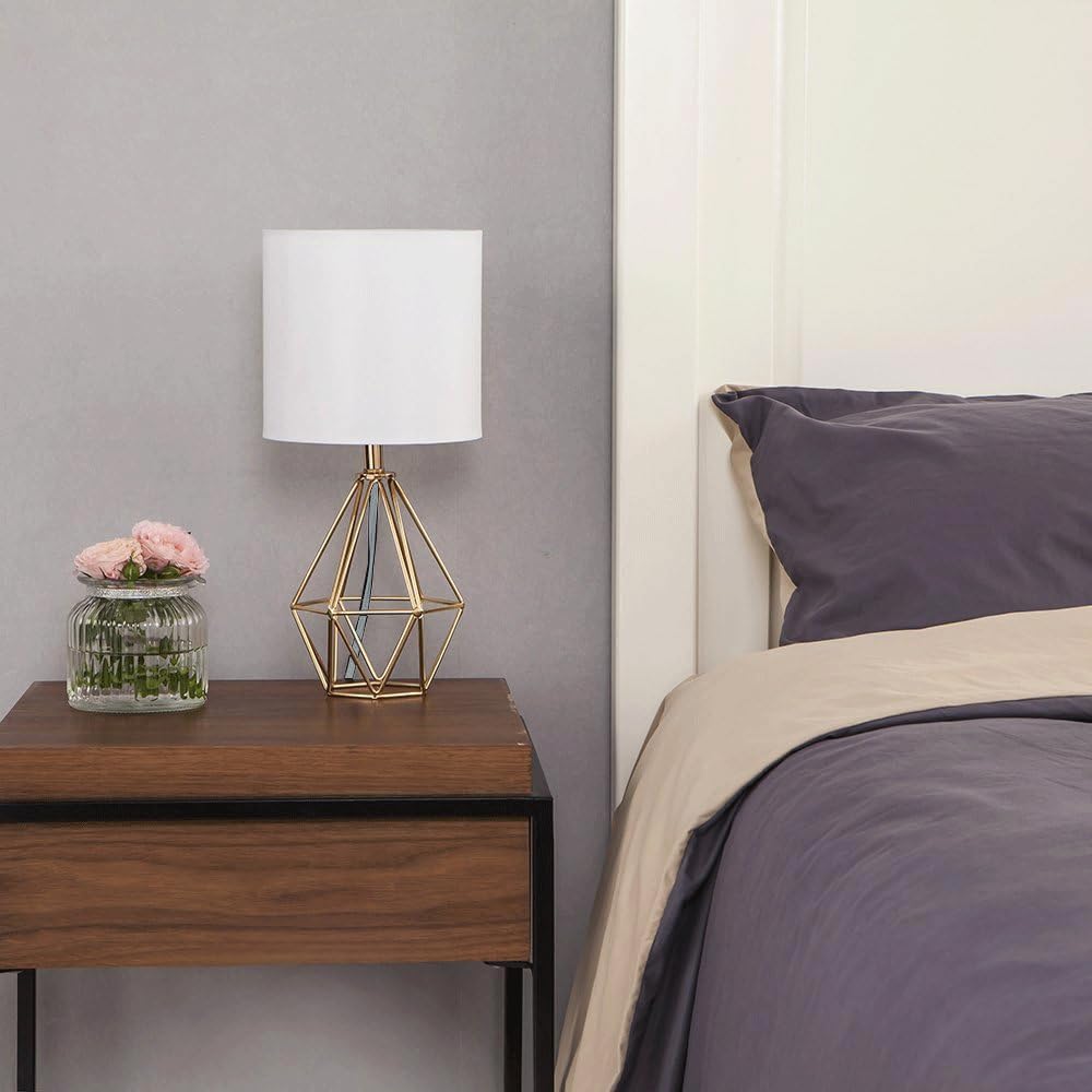 COTULIN gold lamp lit on a bedside table creating cozy ambient lighting