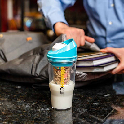 CRUNCHCUP blue on a commuter seat showing portable breakfast solution for busy mornings