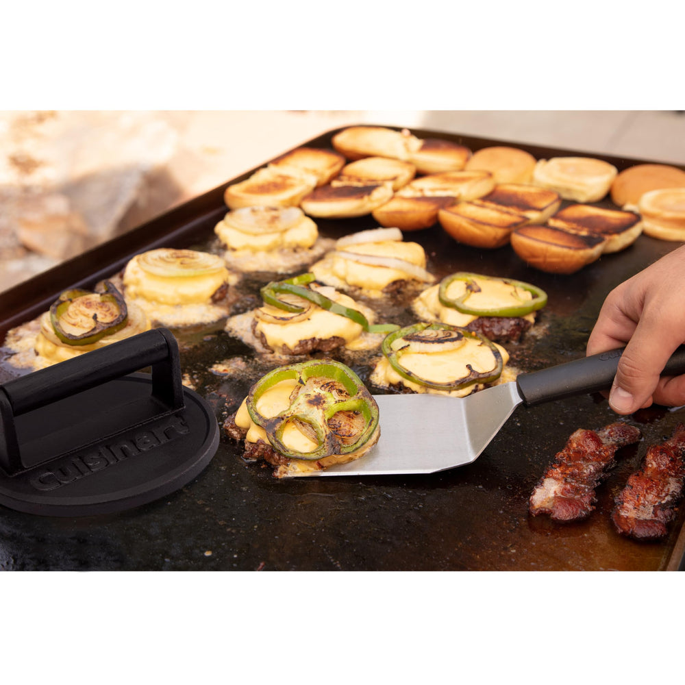 Cuisinart prensa en escena de barbacoa elevando hamburguesas caseras