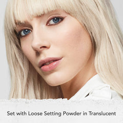 Dermablend powder being applied with brush to set foundation and control shine