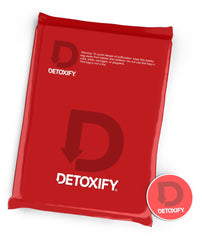 Detoxify botella en mano para comparar tamaño y facilidad de transporte