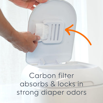 Diaper Genie beside a stack of newborn diapers demonstrating storage capacity