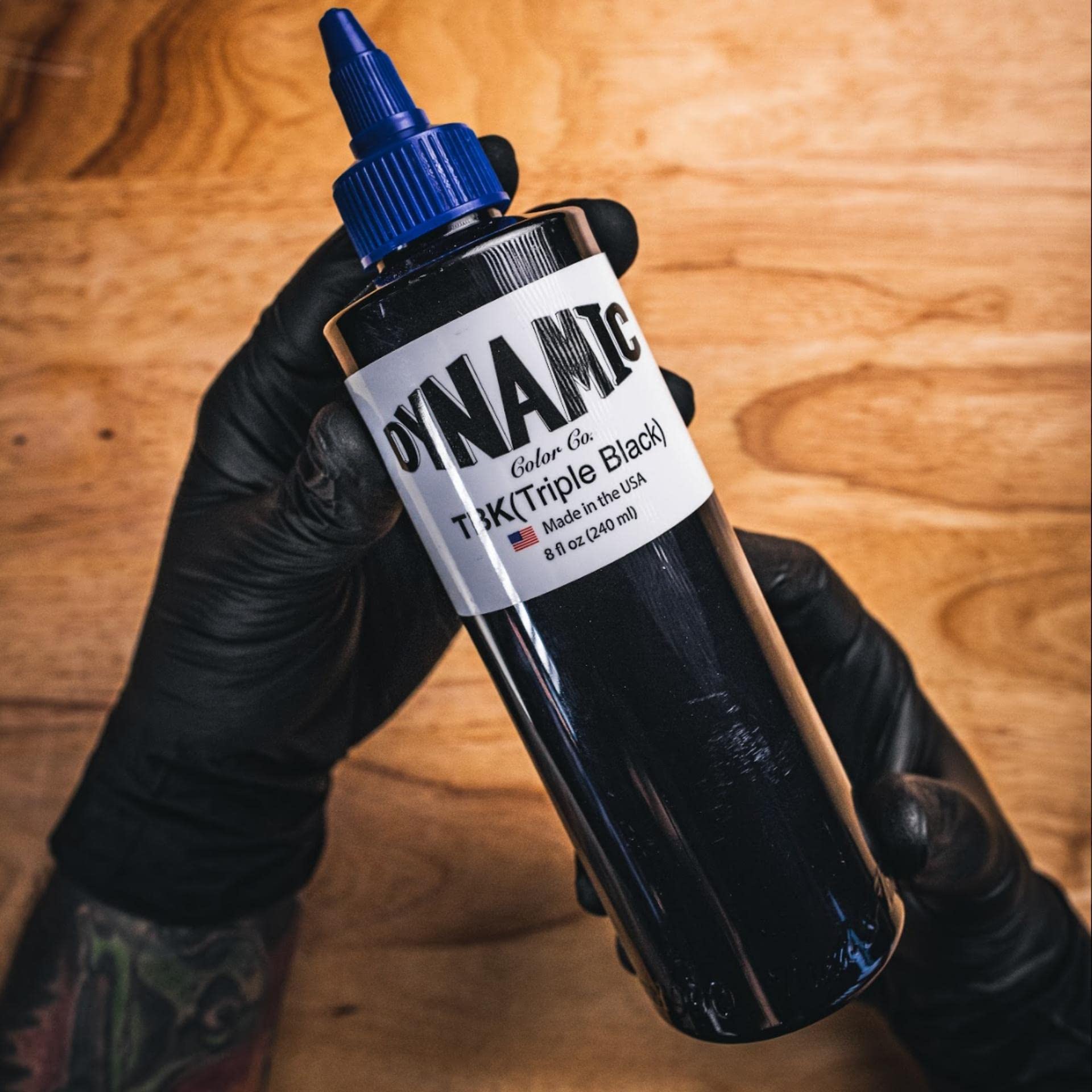 Dynamic Color Co botella al lado de una mano para comparación de tamaño