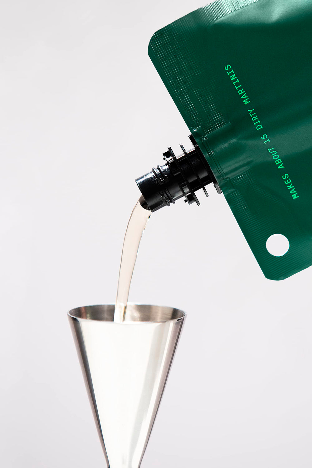 Filthy Olive Brine vertiéndose en un vaso para martini, realza sabor y equilibrio