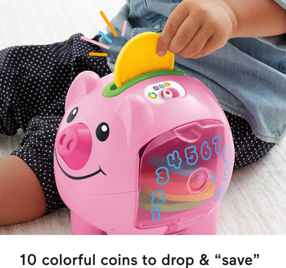 Fisher-Price child playing with piggy bank encouraging fine motor skills and smiles