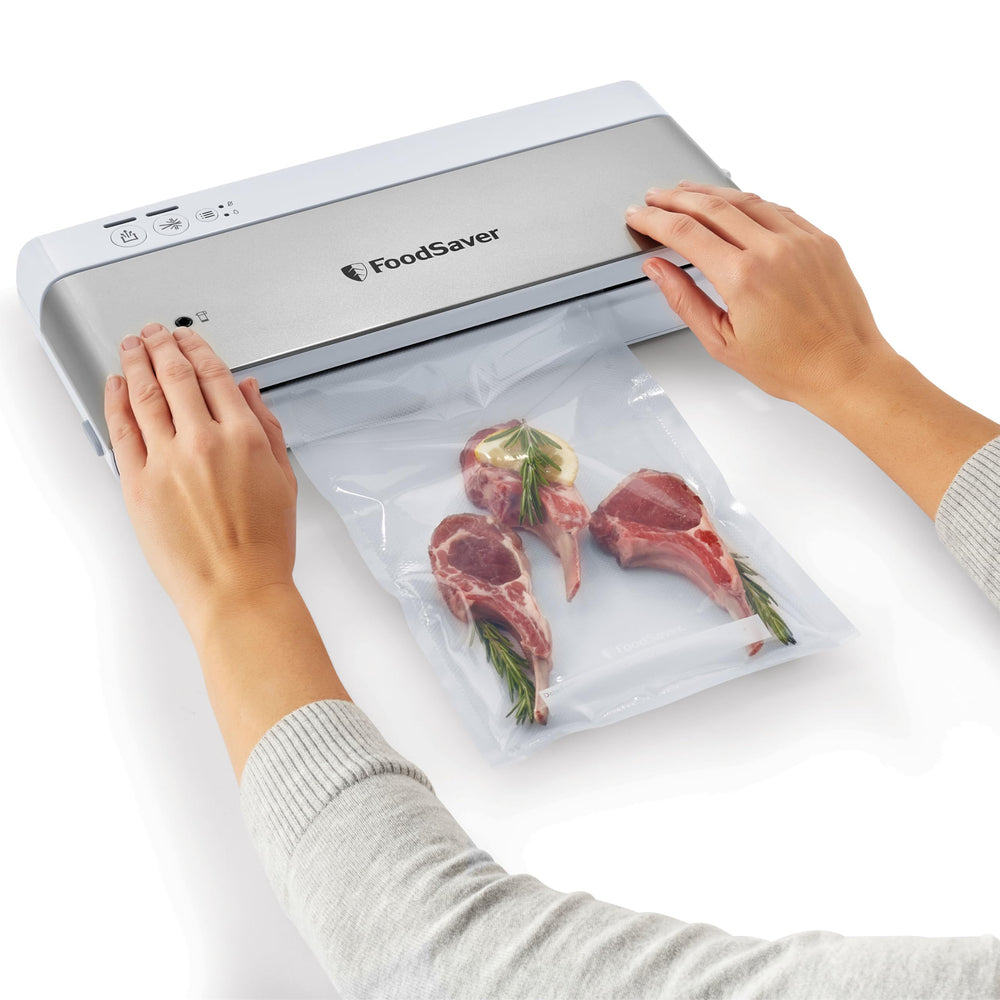 Comparación de tamaño FoodSaver con manos para mostrar escala y comodidad