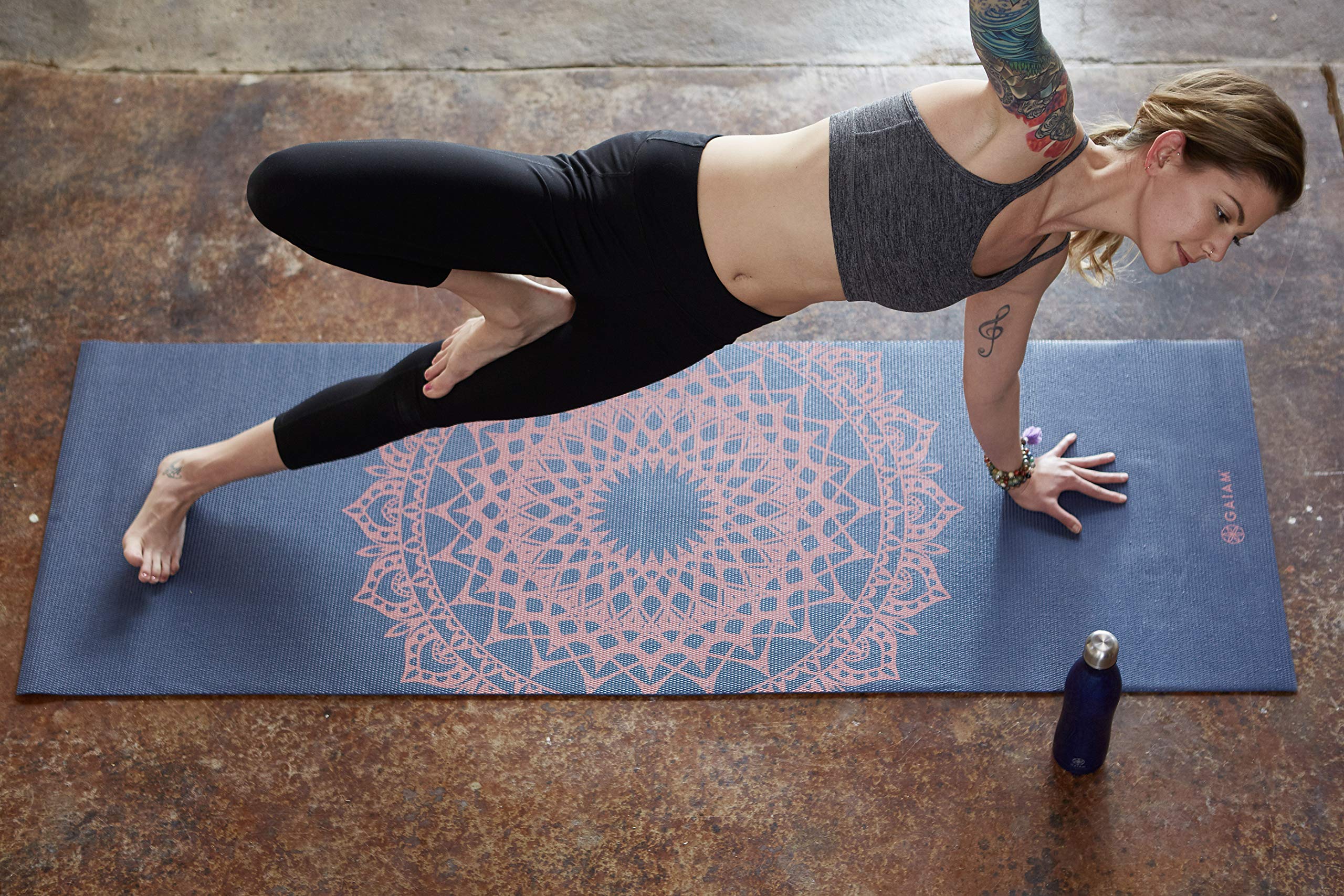 Gaiam esterilla enrollada al lado de una regla para ver dimensiones