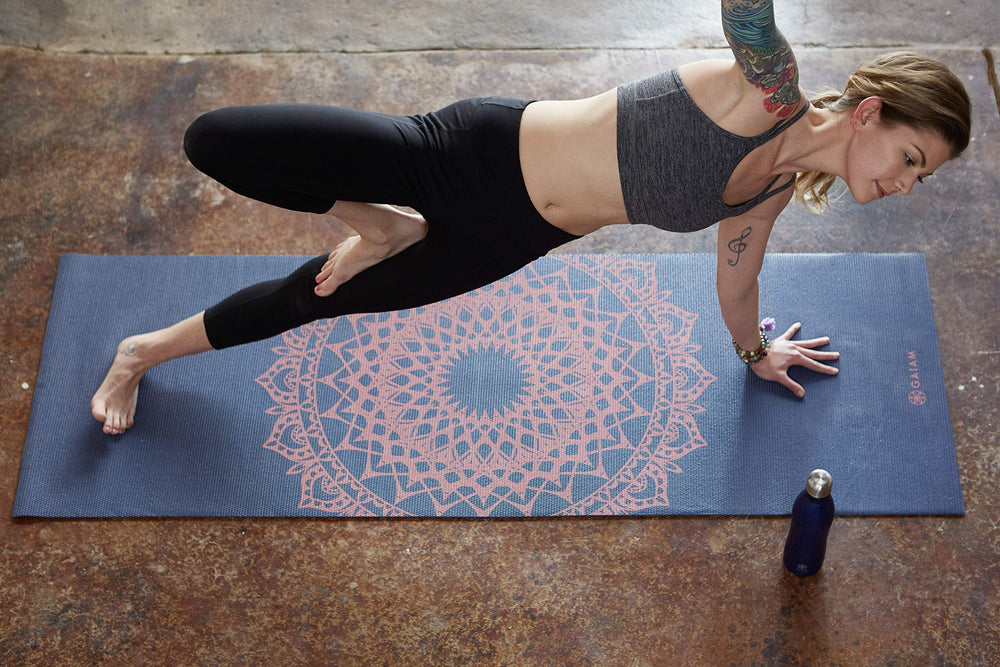 Gaiam esterilla enrollada al lado de una regla para ver dimensiones