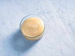 Detalle de la textura cremosa de la salsa Ghirardelli que aporta brillo y cuerpo