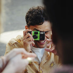 instax Fujifilm cámara en uso en fiesta, captura espontánea de momentos
