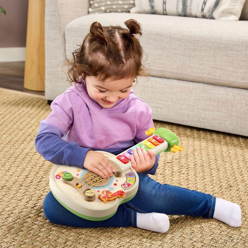 LeapFrog mano infantil rasgueando cuerdas para estimular coordinación