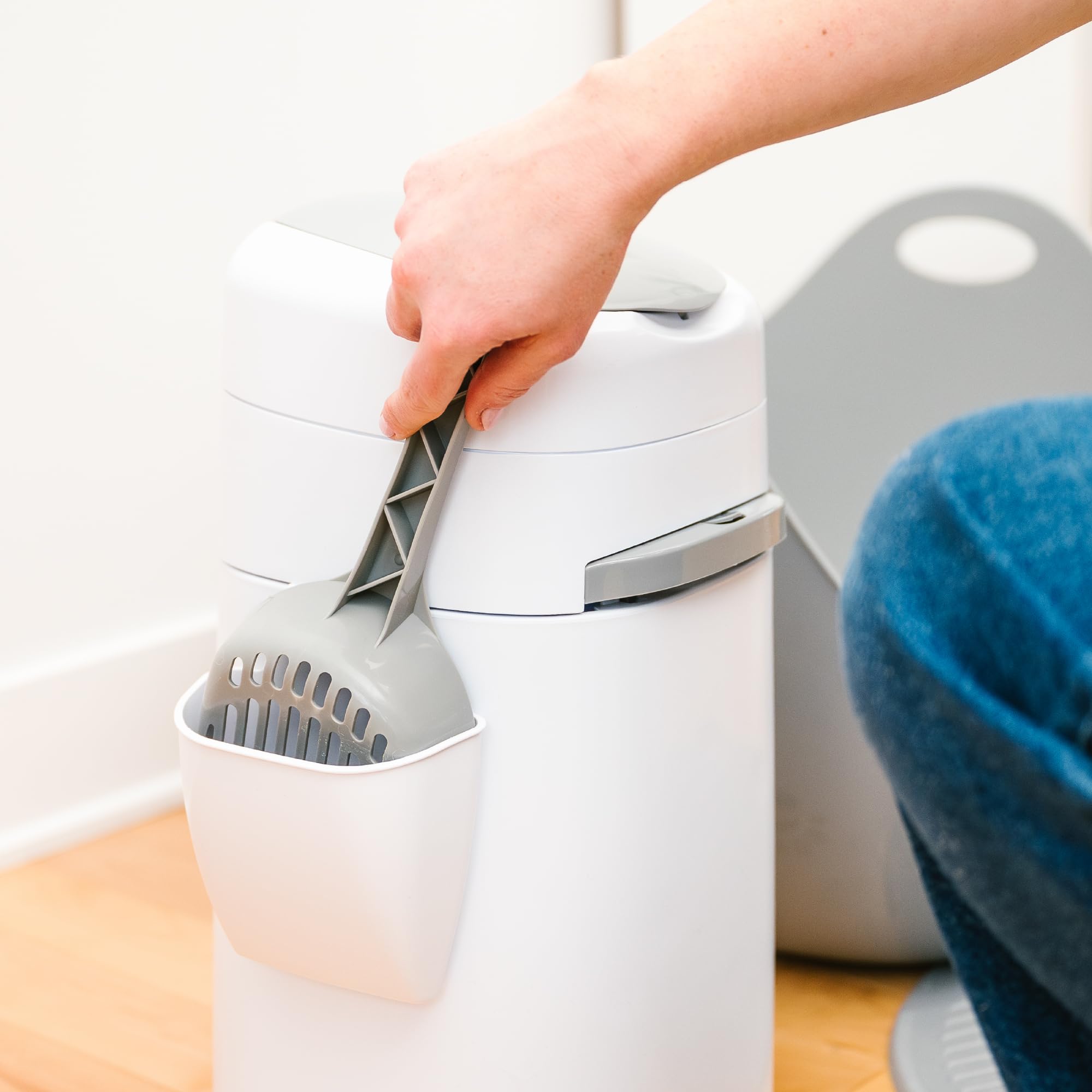 Litter Genie junto a regla mostrando tamaño compacto ideal para apartamentos