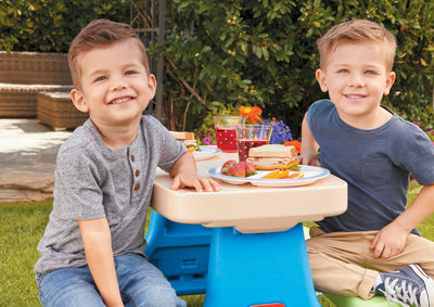 Little Tikes table in backyard with children using it, demonstrating outdoor play and portability