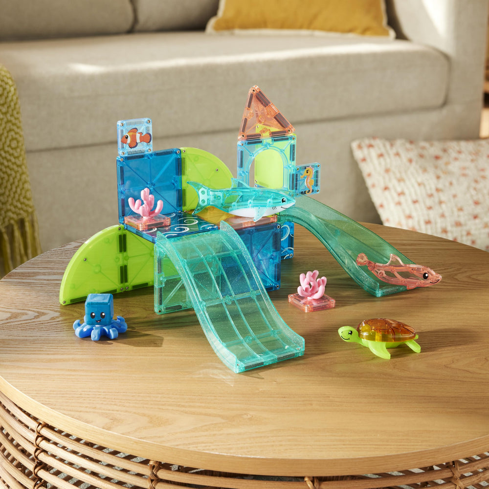 MAGNA-TILES piezas dispuestas en mesa para construir arrecifes, fomenta creatividad inmediata