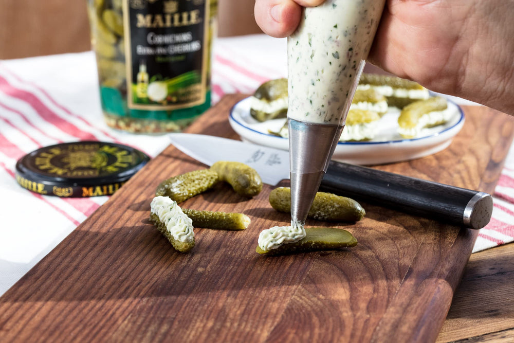 Maille cornichons junto a fruta para comparar tamaño y porción