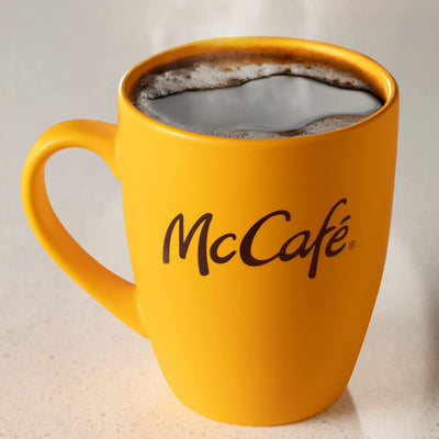 McCafé canister beside a hand for size comparison showing 30 oz value