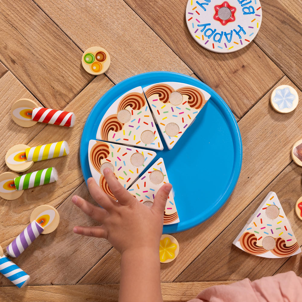 Melissa & Doug cake set staged in playroom showing cooperative play and imaginative party scene