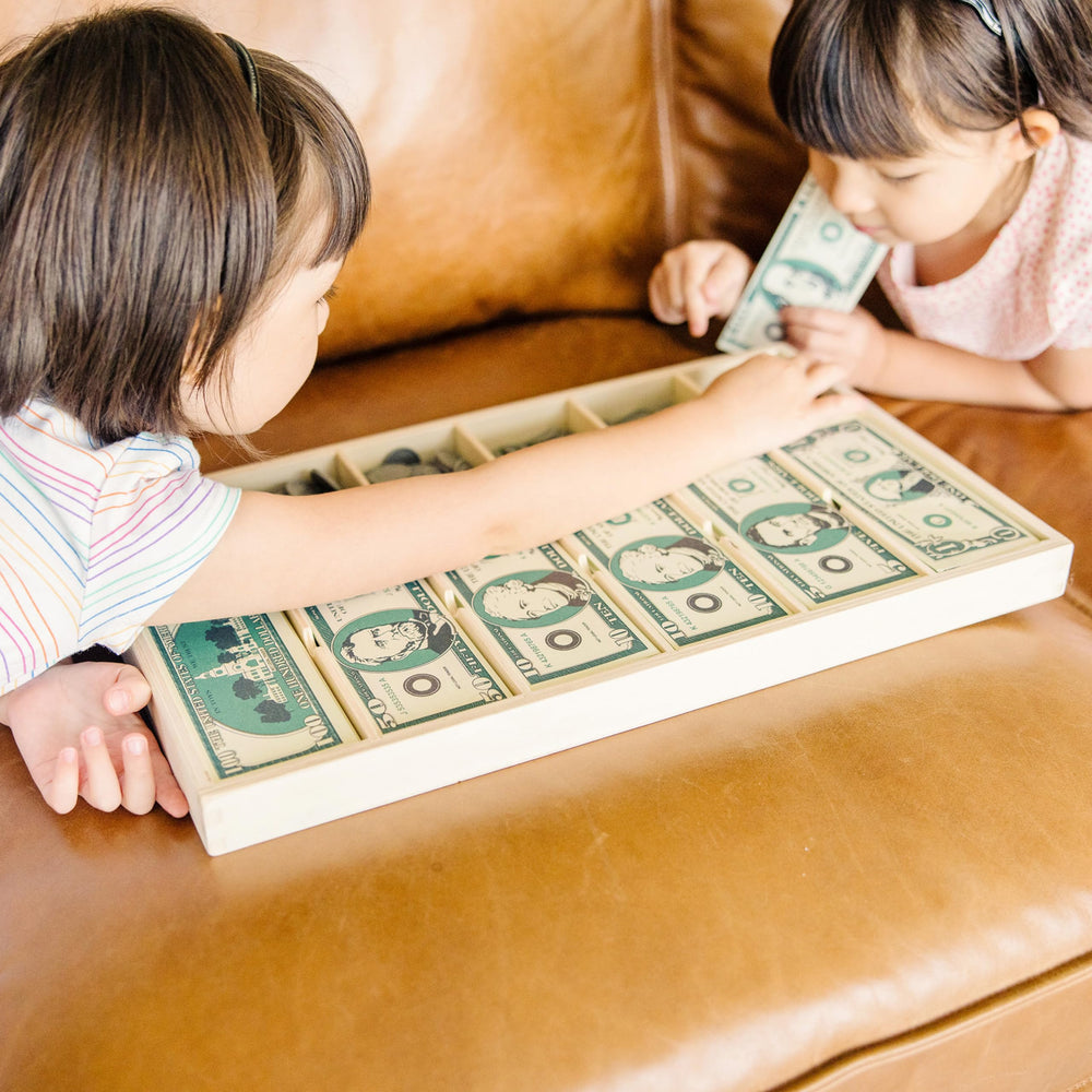 Melissa & Doug manos de niño usando dinero para desarrollar habilidades numéricas