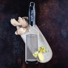 Microplane grater in use over pasta demonstrating even melting and easy finishing