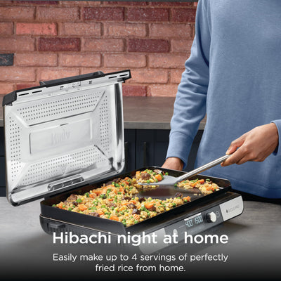 Ninja Sizzle Pro XL searing steaks on grill plate showing high-heat sear and professional finish