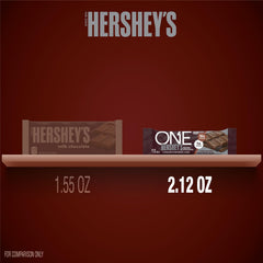 ONE Hershey's barra en mano para comparar tamaño y portabilidad