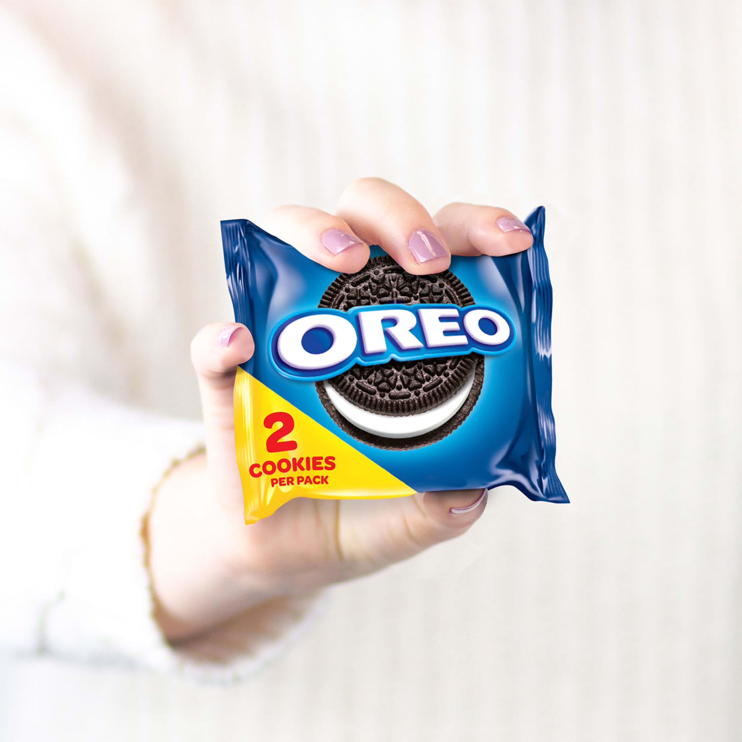 OREO paquete en mano para comparar tamaño y porción práctica
