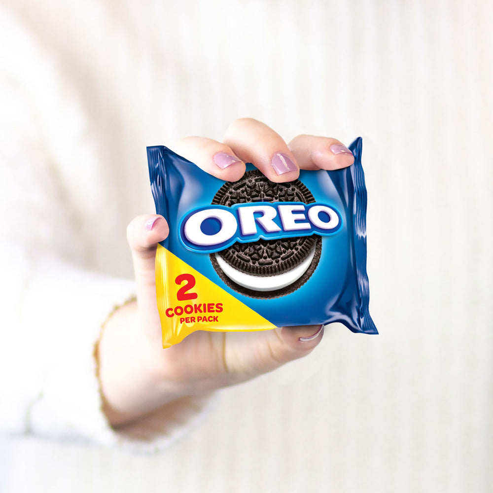 OREO paquete en mano para comparar tamaño y porción práctica