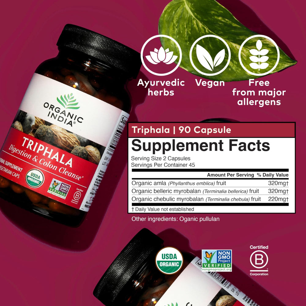 Ambiente de uso: Triphala de ORGANIC INDIA cerca de un vaso de agua y frutas