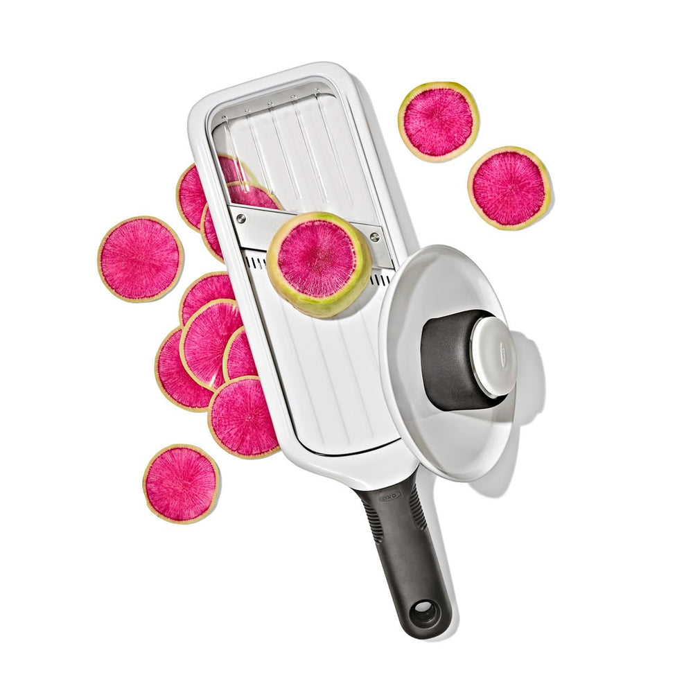 OXO mandoline next to chef knife showing compact size and space savings